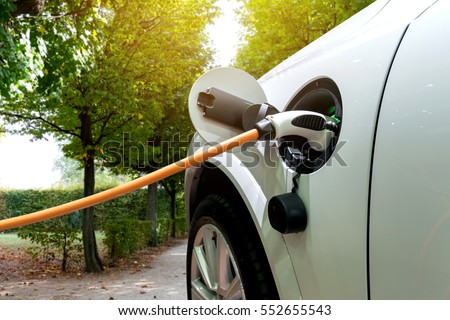 Charging an electric car with the power cable supply plugged in.Flare light effect