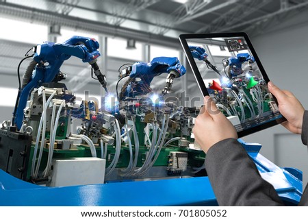 Industrial 4.0 , Augmented reality concept. Hand holding tablet with AR service , maintenance application and calling technician for check destroy part of smart machine in smart factory background