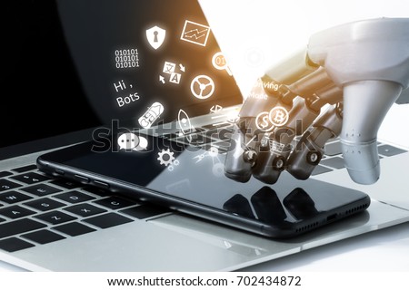 Robot hand use mobile phone on laptop with flare light effect. Robotic , artificial intelligence, chatbot technology concept.