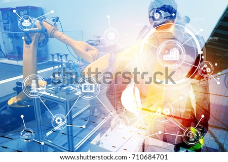 Double exposure of Manufacturing production industrial machine , factory robots arm in smart factory , engineer male stand with his back of machine with flare light effect. Blue tone.