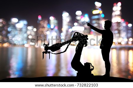 Silhouette of business man command automation robot arm machine technology , industry 4.0 , artificial intelligence  trend concept. Blur Bokeh flare light night building background.