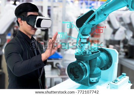 Virtual reality technology in industry 4.0. Business man suit wearing VR glasses to see AR service , Thermal Monitoring motor for check destroy part of smart robot arm machine in smart factory.