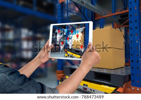 Industrial 4.0 , Augmented reality and smart logistic concept. Hand holding tablet with AR application for check order pick time around the world and supply chain in smart factory background.