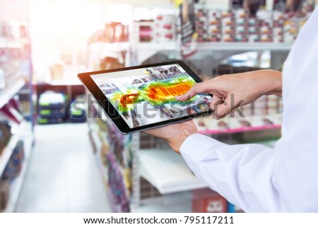 Heatmap Analytic in smart retail shop technology concept. Hand using smart tablet with Pheat sense application check shoppers passed from any point in store.