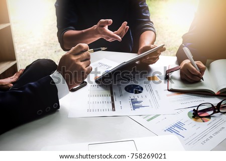 Business people using pen,tablet,notebook are planning a marketing plan to improve the quality of their sales in the future.