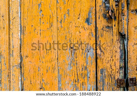 Old wooden wall with yellow cracked paint traces