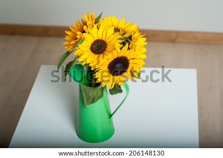 Bouquet of sunflowers in a green vase. Isolated on white