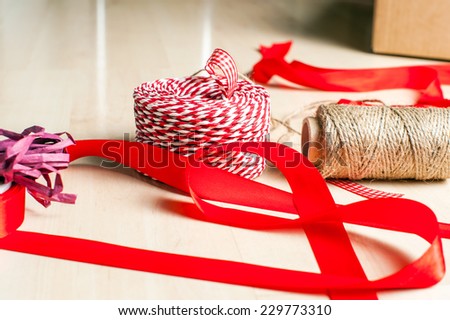 Christmas preparation. Ribbons and accessories for Xmas gift packing on wood floor.