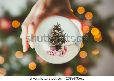 Wrapped gifts under a Christmas tree through glass ball