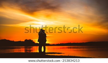 Couple Man and Woman Hugging in Love staying on Beach seaside with Sunset