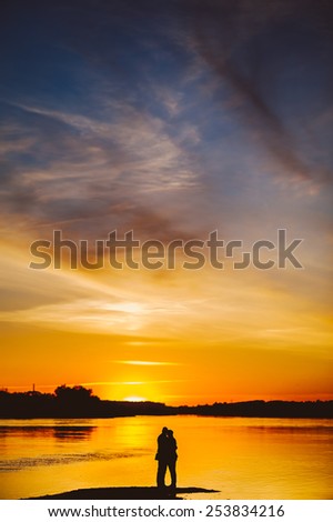 Couple Man and Woman Hugging in Love staying on Beach seaside with Sunset, vertical image