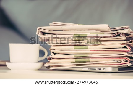 Stack of newspapers with a cup of coffee, vintage edition