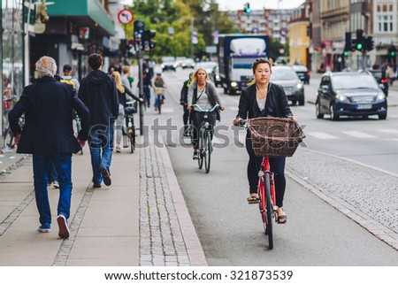 COPENHAGEN, DENMARK - AUGUST 01, 2015: People going by bike in the city. A lot of commuters, students and tourists prefer using bike instead of car or bus to move around the city.