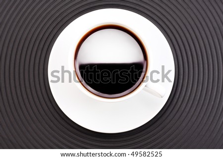 a cup of coffee on dark circle