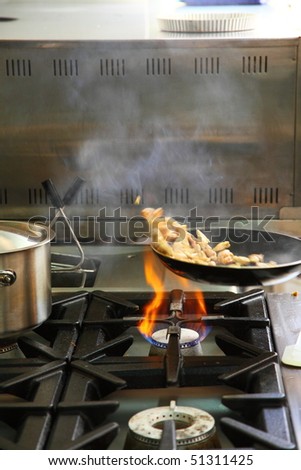 Chef cooking chicken in wok pan