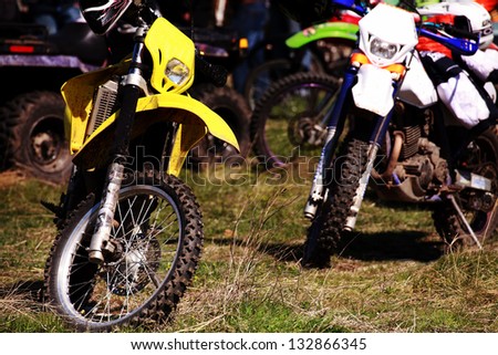 few motocross bikes staying in the grass