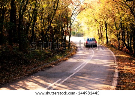 abstract blurred car in autumn forest road