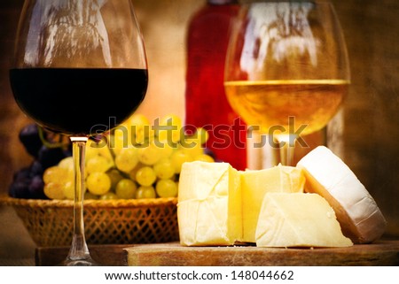 vintage textured still-life food background with cheese,  wine and grape