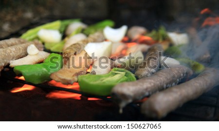 outdoor bbq covered in flames- beacon and vegetable on grill plate