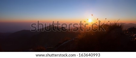 low light sunrise panoramic mountain landscape with sun star