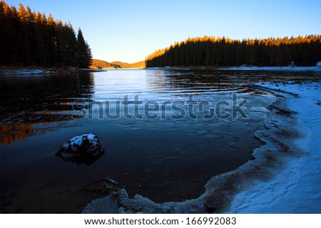 blue lake covered with ice landscape in dusk time