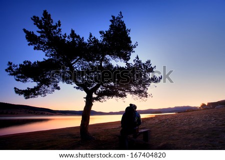 man watching stunning red sunset near lake- HDR colorful nature background