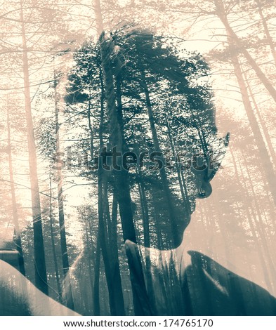 Abstract soft focused duotoned double exposure portrait of woman and black forest