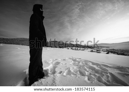 black and white winter landscape with man hiker in snow meadows