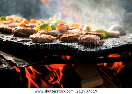 hand-made bbq in forest with beacon and vegetable on stone plate
