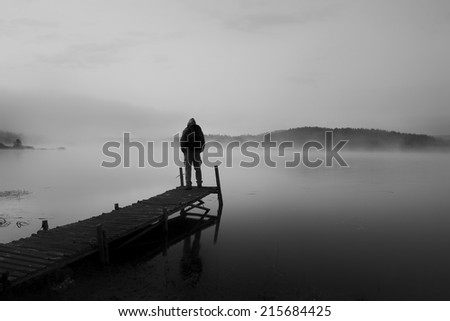 black and white abstract landscape with man stand on wooden bridge in sunrise lake