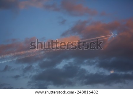 airplane flying close to the moon- red cloudy sunset