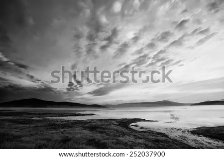 black and white high contrasted sky above the mountain lake