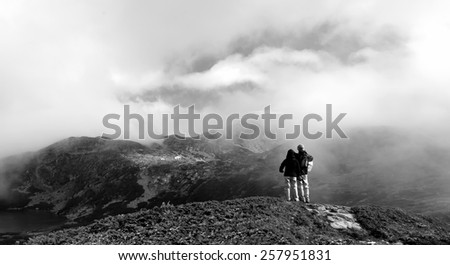 black and white mountain landscape with coupe tourist stay in misty peak