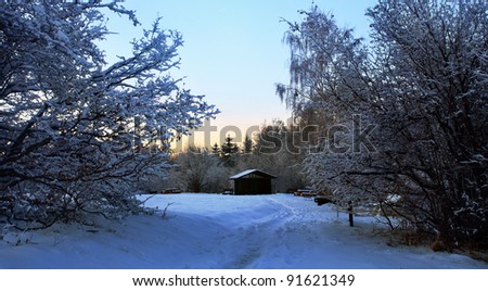 low light winter sunset landscape with wooden shelter