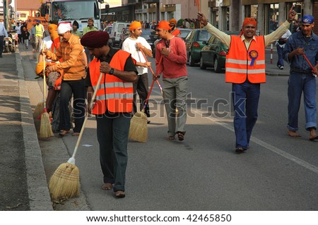 BRESCIA, ITALY - APRIL 30: Street cleaners sweep street before \'Baisakhi\' procession April 30, 2005 in Brescia, Italy.  20,000 Sikh Indians residing in Italy celebrate the annual procession.