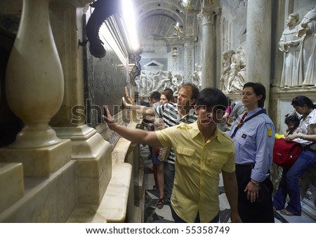 PADUA,ITALY - JUN 13:Feast of St.Anthony of Padua,the pilgrims pray at the tomb of St.Anthony parading with devotion,touching and kissing the marble plaque,June 13,2010 in Padua,Italy