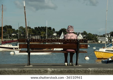single grand mother on a bench looking at the sea