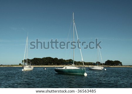 three sailing boats on quiet sea
