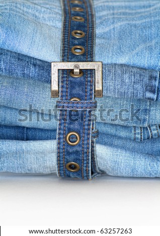 Stack of folded blue jeans with jean belt