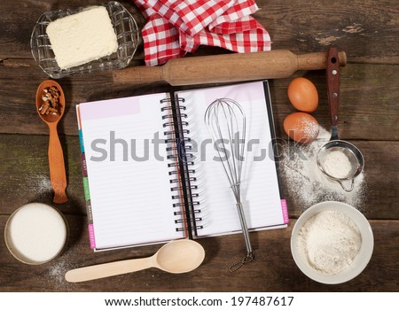 Baking cake in rural kitchen - dough recipe ingredients (eggs, flour, butter, sugar) and rolling pin on vintage wood table. Rustic background with free text space.