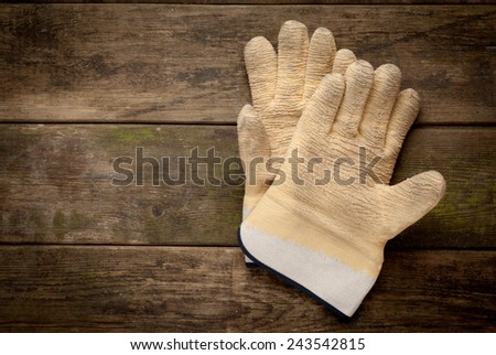 Working gloves on old wooden background with copy space