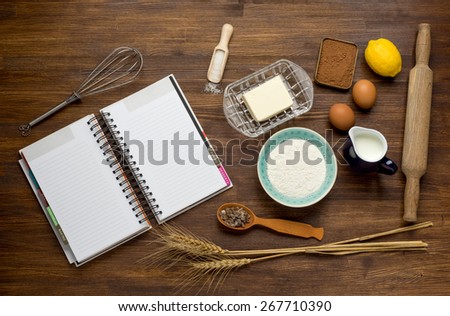 Baking cake in rural kitchen - dough recipe ingredients (eggs, flour, milk, butter, sugar) on vintage wooden table from above. Background layout with free text space.