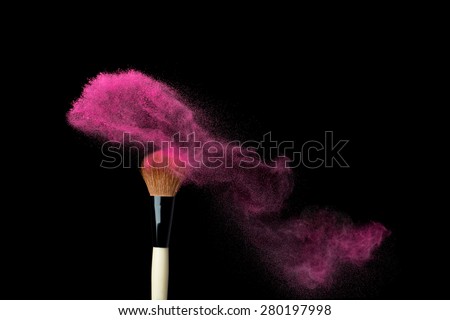 powderbrush on black background with pink powder splash close up
