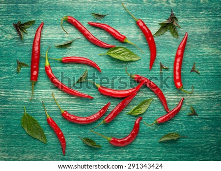 Red Hot Chili Peppers with herbs and spices over wooden background - cooking or spicy food concept.