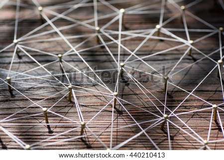 Linking entities. Network, networking, social media, internet communication abstract. A small  connected to  larger . Web of gold wires on rustic wood.