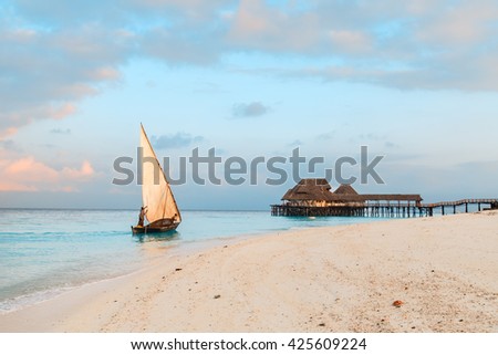 Beautiful sunrise over ocean with fishing boat, fishermen, hut, Nungwi, Kendwa, Zanzibar island, Tanzania