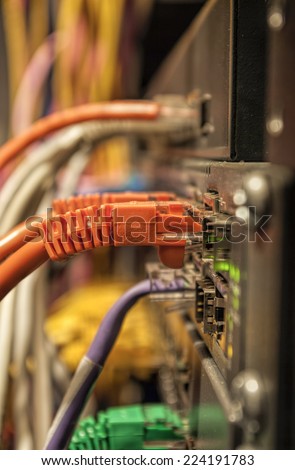 Data Center III Multicolored network cords plugged into a data center patch panel.