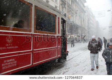 ISTANBUL,TURKEY-JAN UARY 8: Unidentified pedestrians walk down Istiklal Street on a snowy day on January 8, 2013 in Istanbul, Turkey.Istiklal Street is one of the popular destinations in Istanbul.