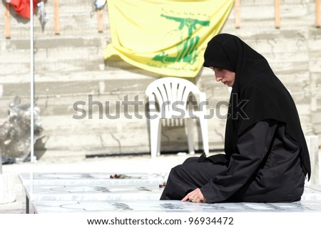 TYRE,LEBANON-OCTOBER 23: An unidentified Lebanese woman is praying near the grave of her family who died in Israel bombardment in Qana on October 23, 2006 ,in Tyre, Lebanon.