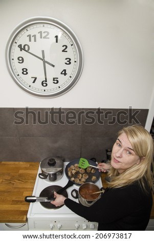 Woman preparing dinner in a real home kitchen, wide angle shot from above
